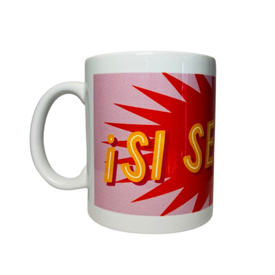 side view of a White mug with the phrase SI SE PUEDE in orange lettering with a red and pink text bubble background.