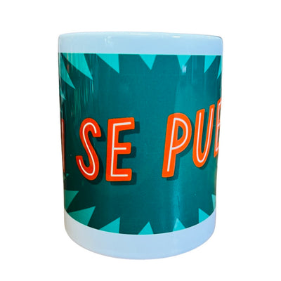 front  view of a White mug with the phrase SI SE PUEDE in orange lettering with a Green and dark green text bubble background.