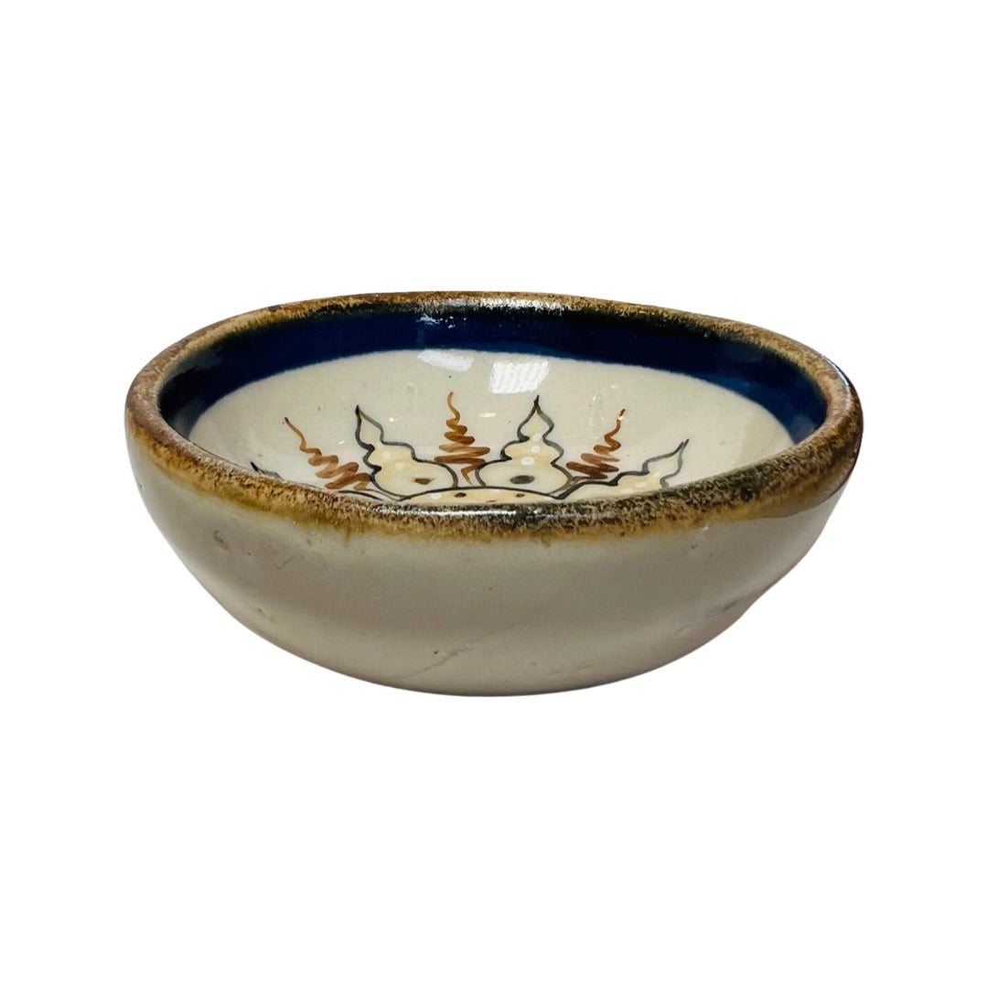 side view of a Yellow and blue stoneware bowl with an image of a smiling sun