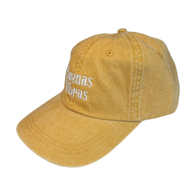 Side view of a yellow hat with the phrase Buenas Vibras in white lettering