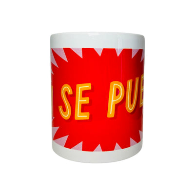 White mug with the phrase SI SE PUEDE in orange lettering with a red and pink text bubble background.