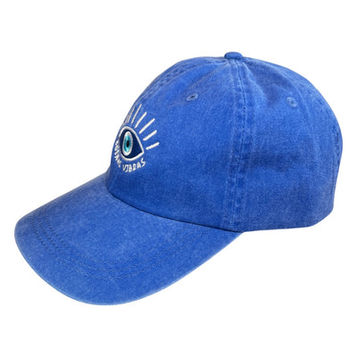 Side view of a blue heathered hat with an image of an eye and the phrase Buenas Vibras in white embroidered lettering