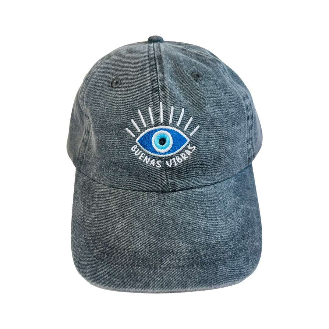 Front view of a black heathered hat with an image of an eye and the phrase Buenas Vibras in white embroidered lettering