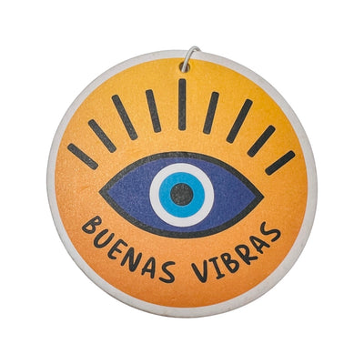 Round yellow air freshener with an image of an eye and the phrase buenas vibras in black lettering.