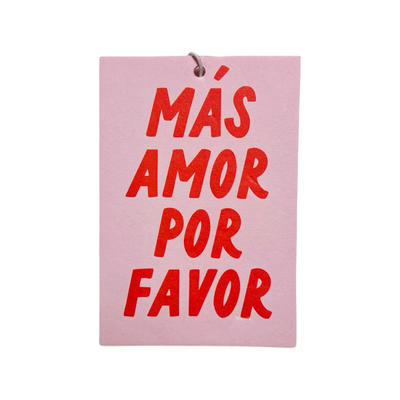 Rectangular air freshener with "Más Amor Por Favor" written in bold letters; light pink  background with red text