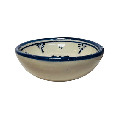 Side view of a Blue and cream stoneware bowl with an image of a blue flower