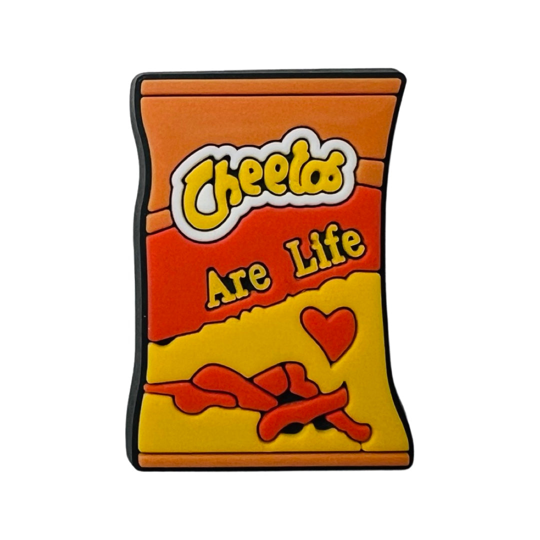 A chancla, or croc, charm in the shape of a cheetos bag with the phrase Cheetos are life in yellow lettering.