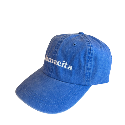 side view of a blue hat with the word Mamacita in white lettering