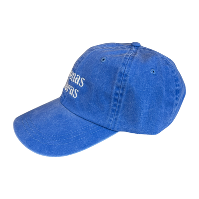 Side view of a blue hat with the phrase Buenas Vibras in white lettering