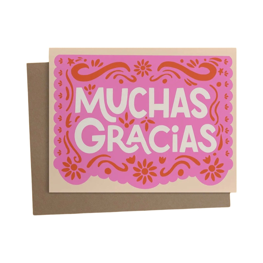 beige card with an image of pink papel picado and the phrase Muchas Gracias in white lettering