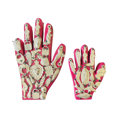 a set of Handmade wooden milagro hands in pink. Design features a variety of mini milagro charms.