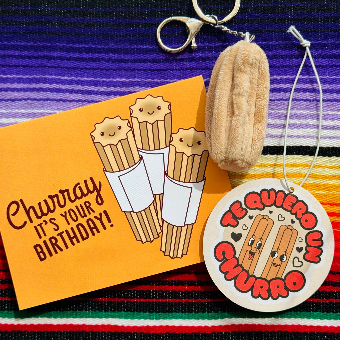 Photo of churro themed greeting card, air freshener, & plush keychain