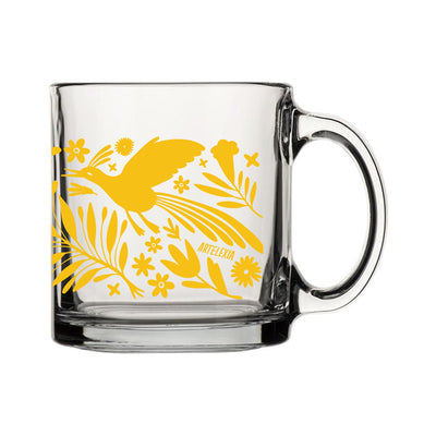 Front view of clear glass mug featuring a wraparound print of a yellow otomi design