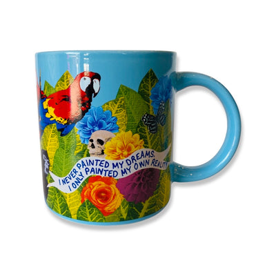 Side view of blue Frida dream mug features phrase, "I never painted my dreams, I only painted my own reality." Design features animals, colorful flowers, and green leafs. 