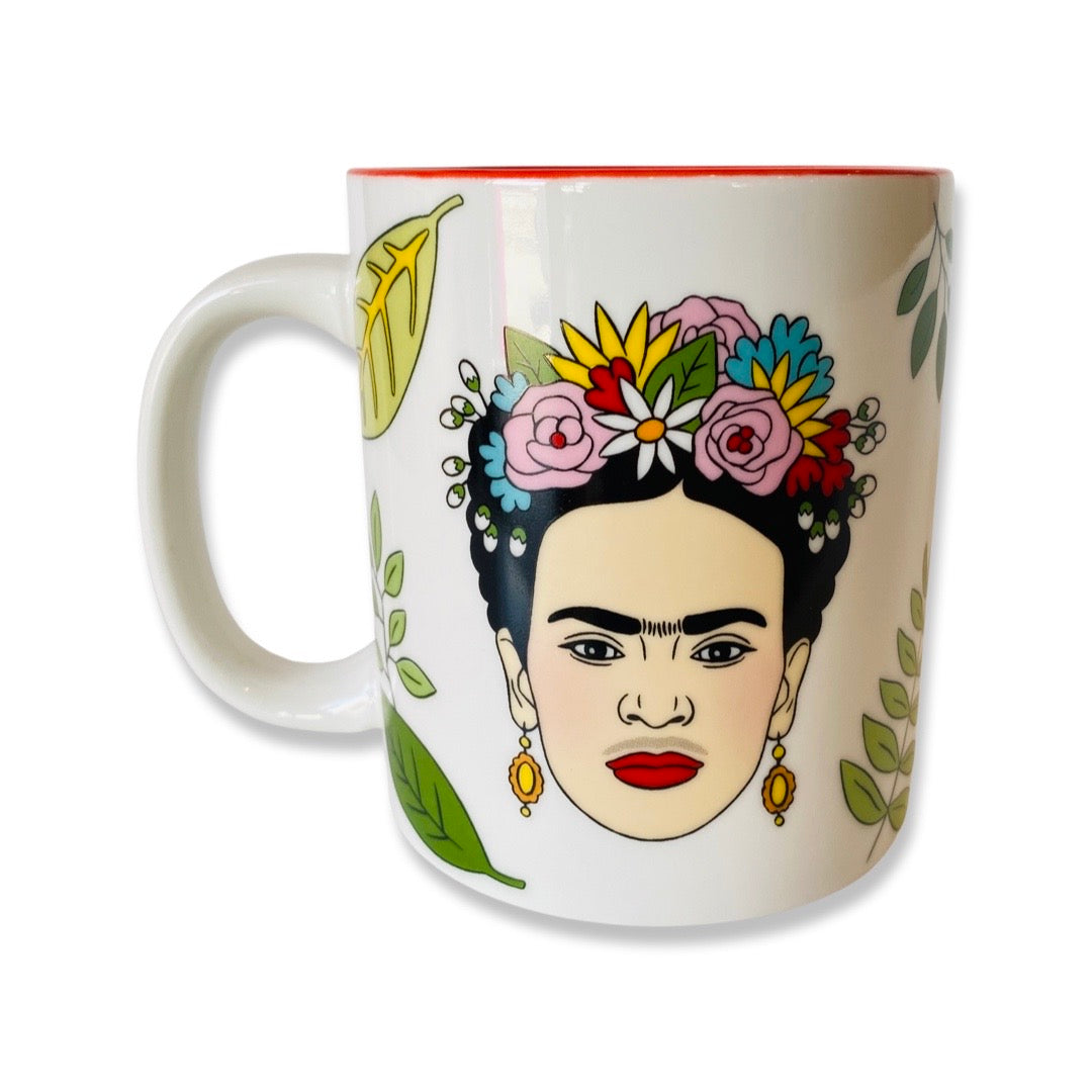 Frida Floral mug features Frida Kahlo with a colorful flower crown. Design features green plants. 