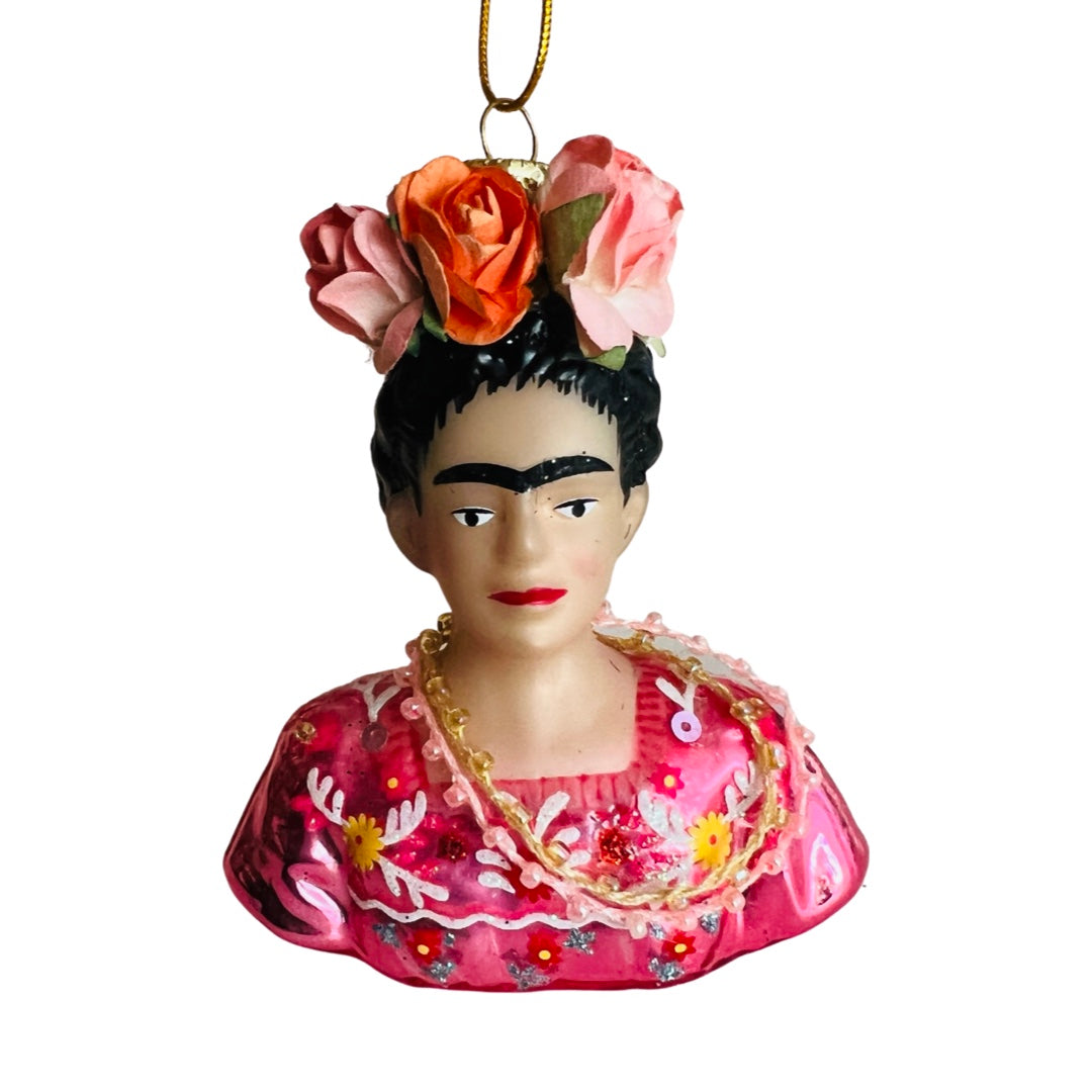  Hand-painted glass Frida ornament in pink. Frida is wearing a flower crown and a pink traditional  top. 