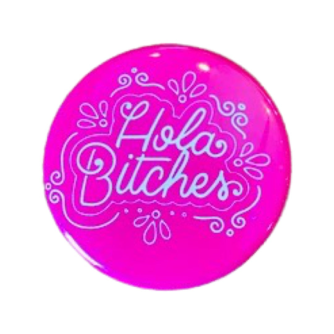 Pink round pin button with the phrase Hola Bitches in white lettering