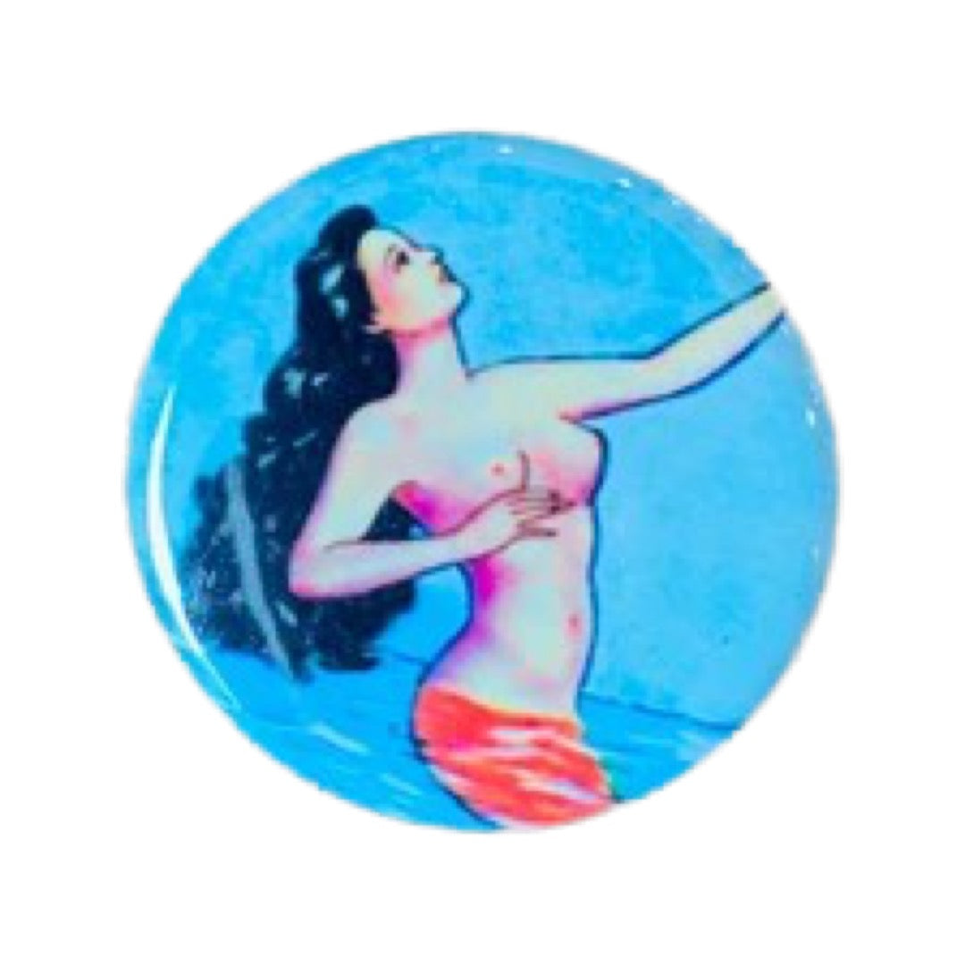 Round pin button with an image of a topless mermaid.