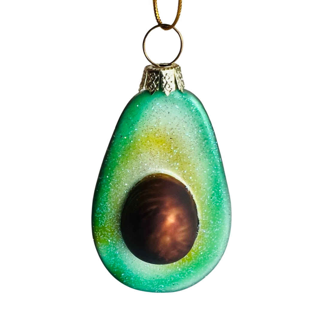 Hand-painted glass Avocado ornament with glitter accents. Avocado ornament is cut in half, showing pit.