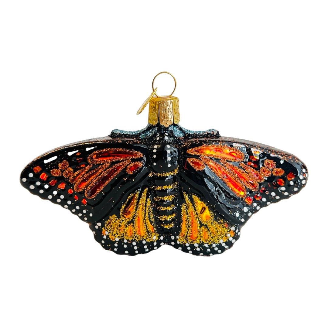 Glass monarch ornament with glitter accents. 