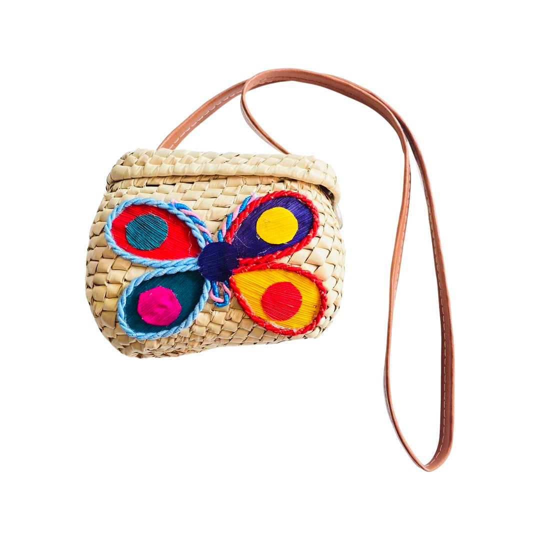 Girl's mini woven purse with colorful butterfly design and brown leather strap.