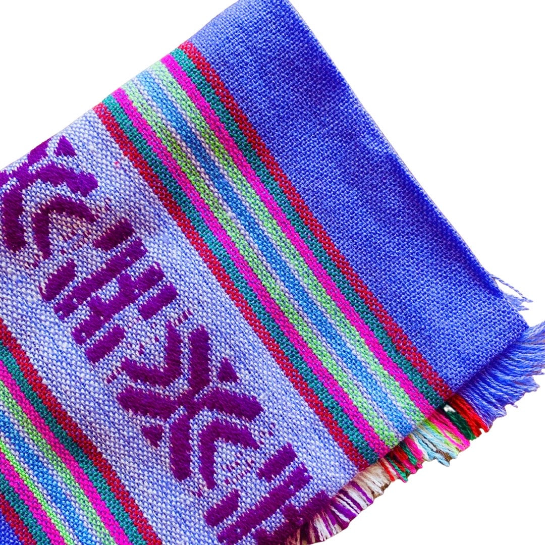 Close up of purple Mexican Servilleta. Design features multicolored stripes with pattern.