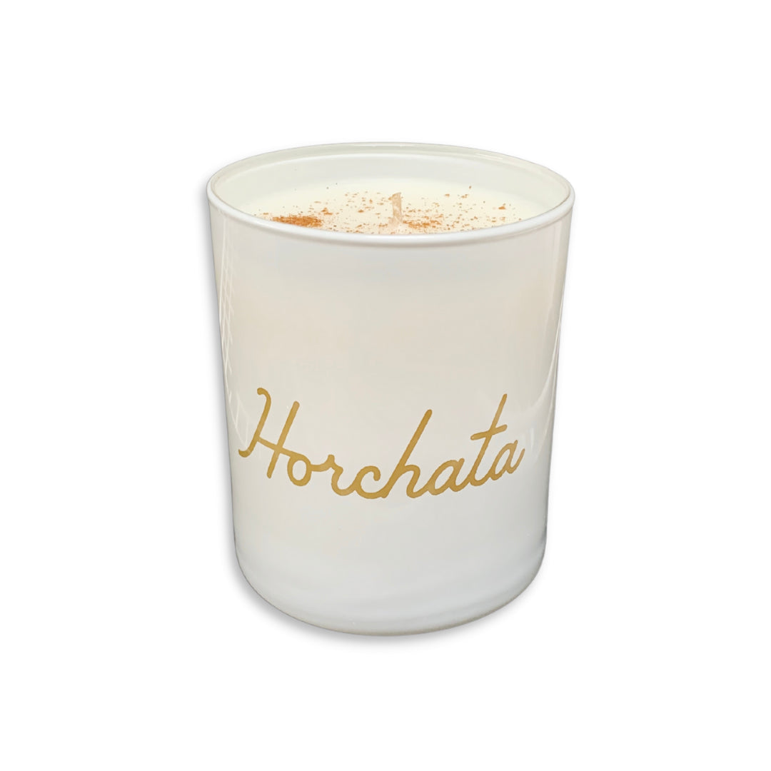 White horchata (cinnamon & vanilla) scented candle. Candle reads Horchata in cursive with light brown lettering.