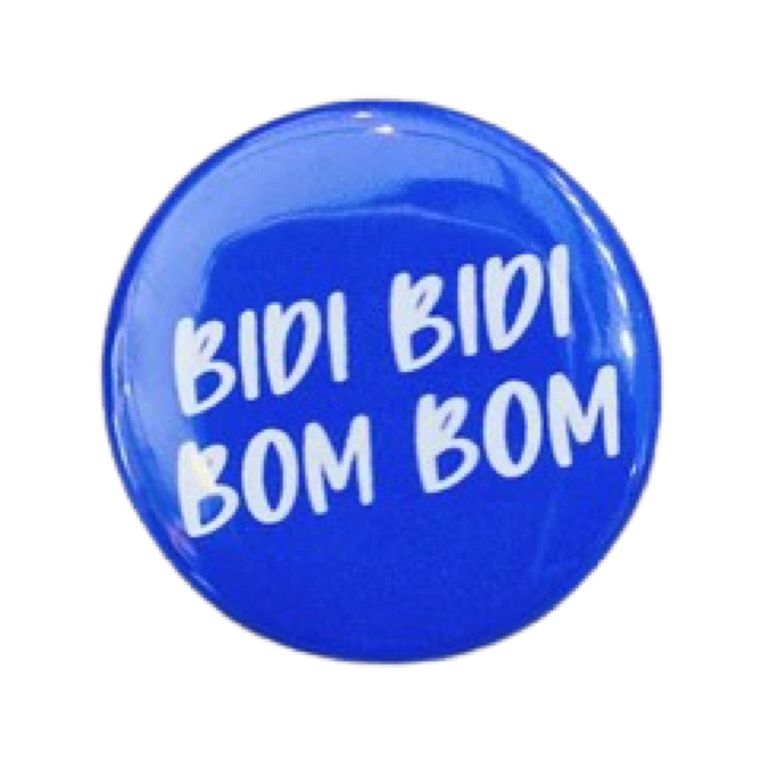 Purple round pin button with the phrase Bidi Bidi Bom Bom in white lettering