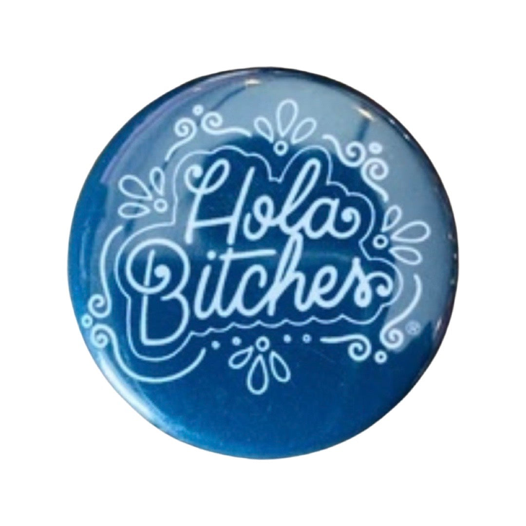Black round pin button with the phrase Hola Bitches in white lettering