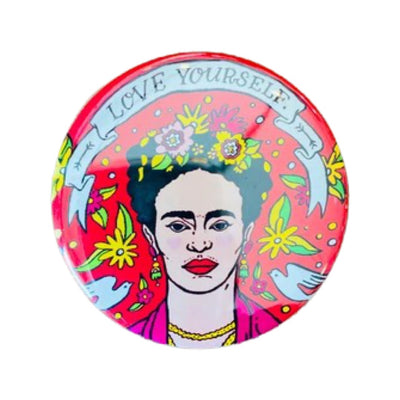 Round pin button with an image of Frida Kahlo and features a banner on the top with the pjrase Love Yourself