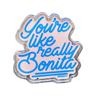 Clear acrylic pin with blue writing that reads "You're like really Bonita".