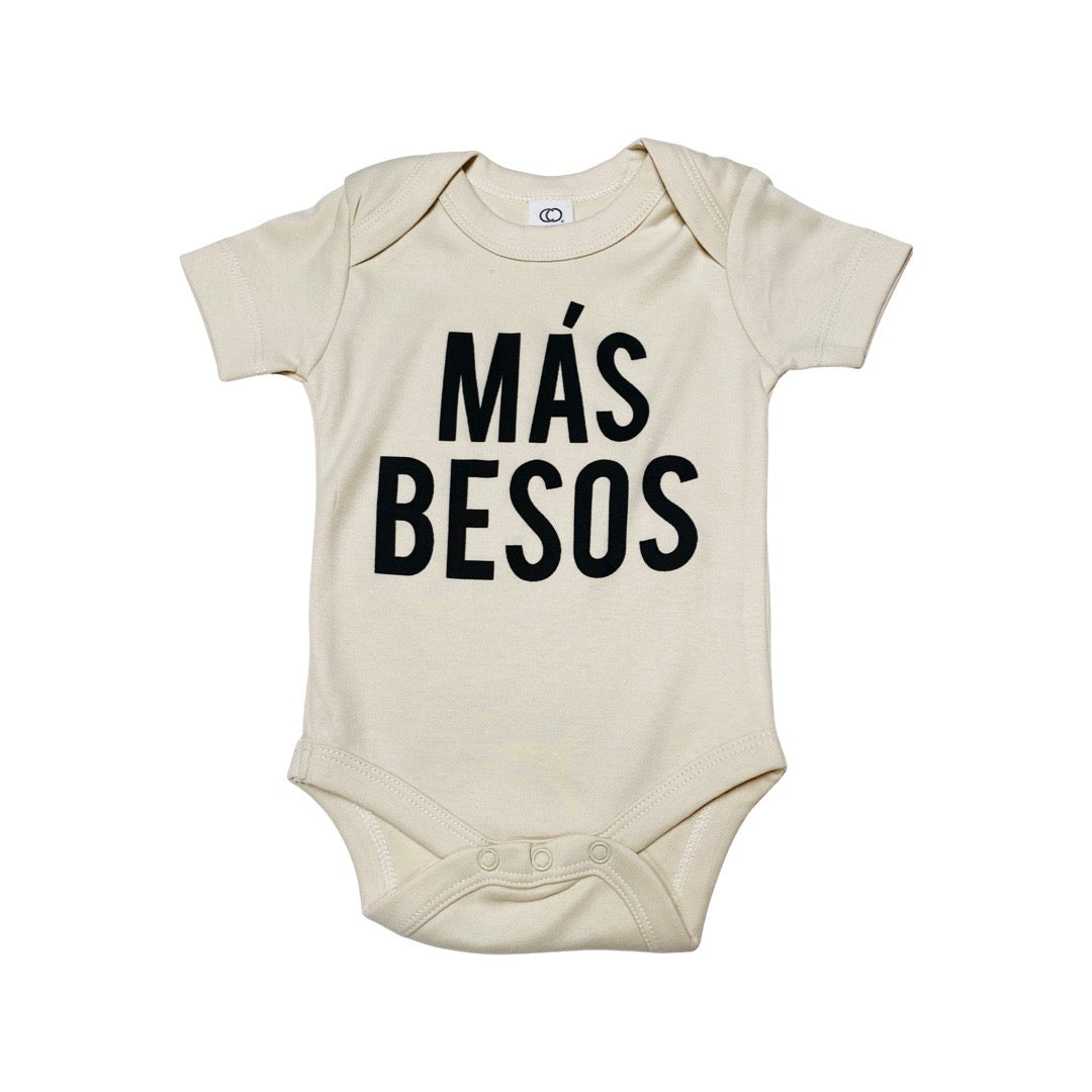 White, "Mas Besos" phrase baby onesie with black detail. 