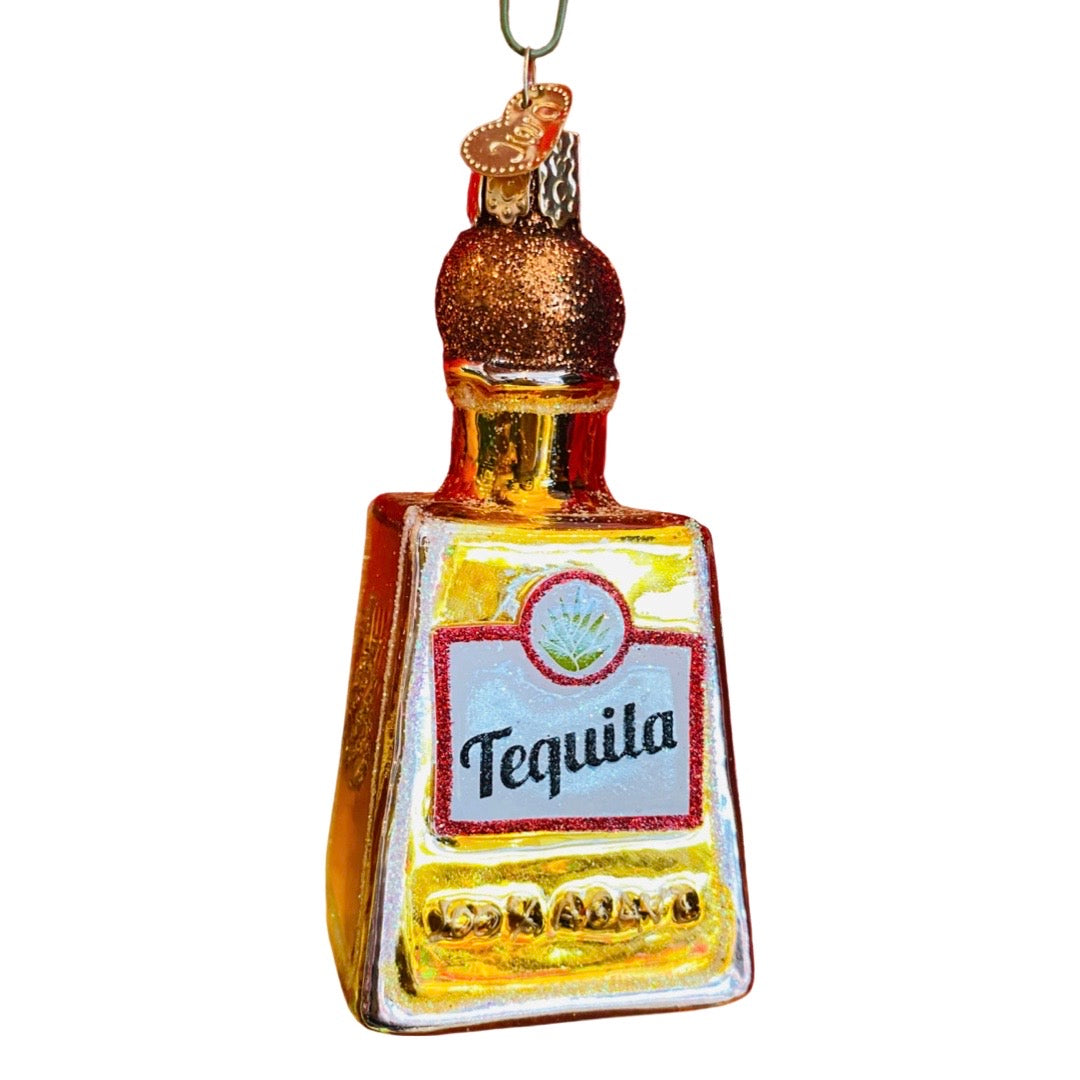 Glass christmas ornament that looks like a gold tequila bottle. Text on the label of the bottle reads "tequila"