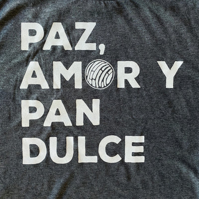 Close up of dark gray unisex, "Paz, Amor Y Pan Dulce" phrase t-shirt with white detail.