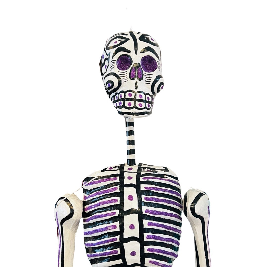 Close up view of a life size skeleton from the chest up. Features glitter accents on the eyes and ribcage.