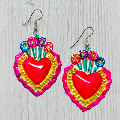 Colorful tin sacred heart earrings with flowers on top of heart.
