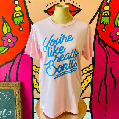 Pink, "You're Like Really Bonita" phrase t-shirt with light blue detail pictured on mannequin. 