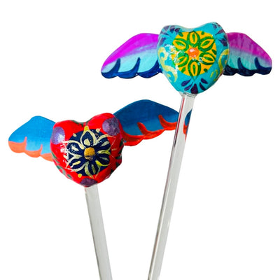 Brightly colorful heart with wings glass stir sticks. Design features flowers in the middle of the heart.
