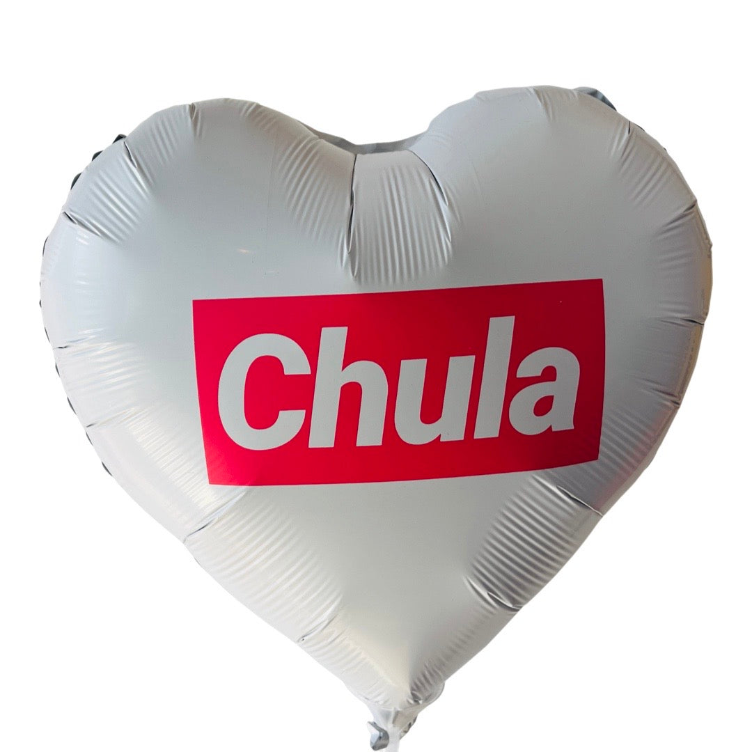 White heart shaped balloon with pink accents that reads, "Chula". 