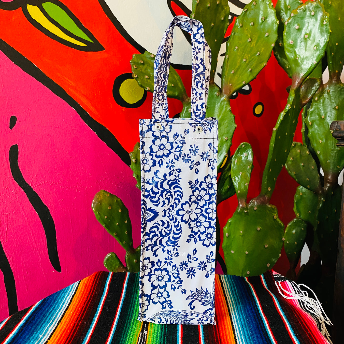 OilCloth wine bottle gift bag in white with a blue floral design.