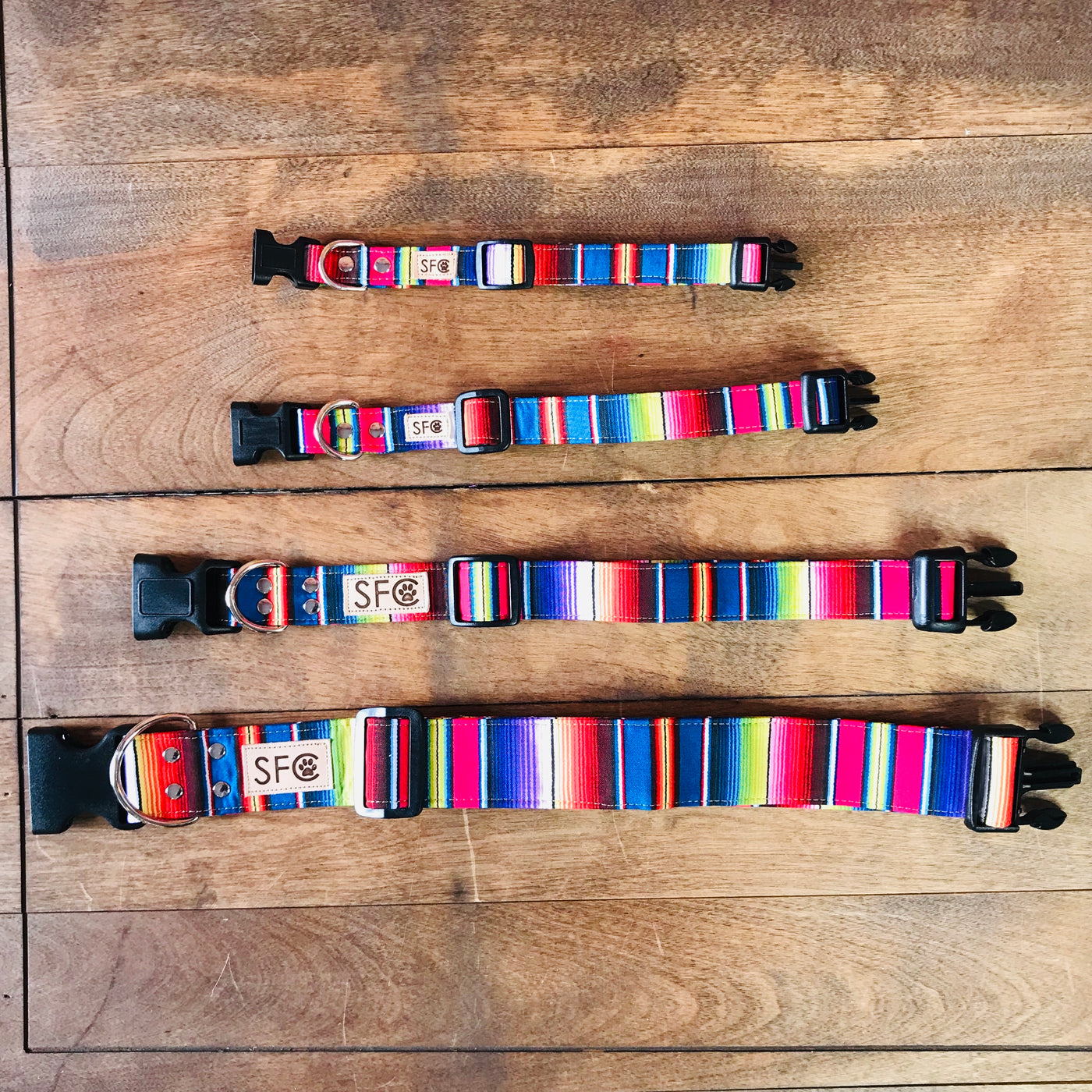 Four multicolored serape dog collars ranging in different sizes.