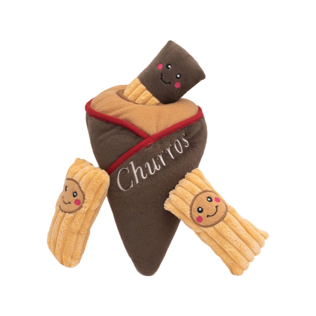 A plush churro cone with three mini plush curros with smiley faces. All mini curros feature a smiley face and the cone features the words churros in white lettering.