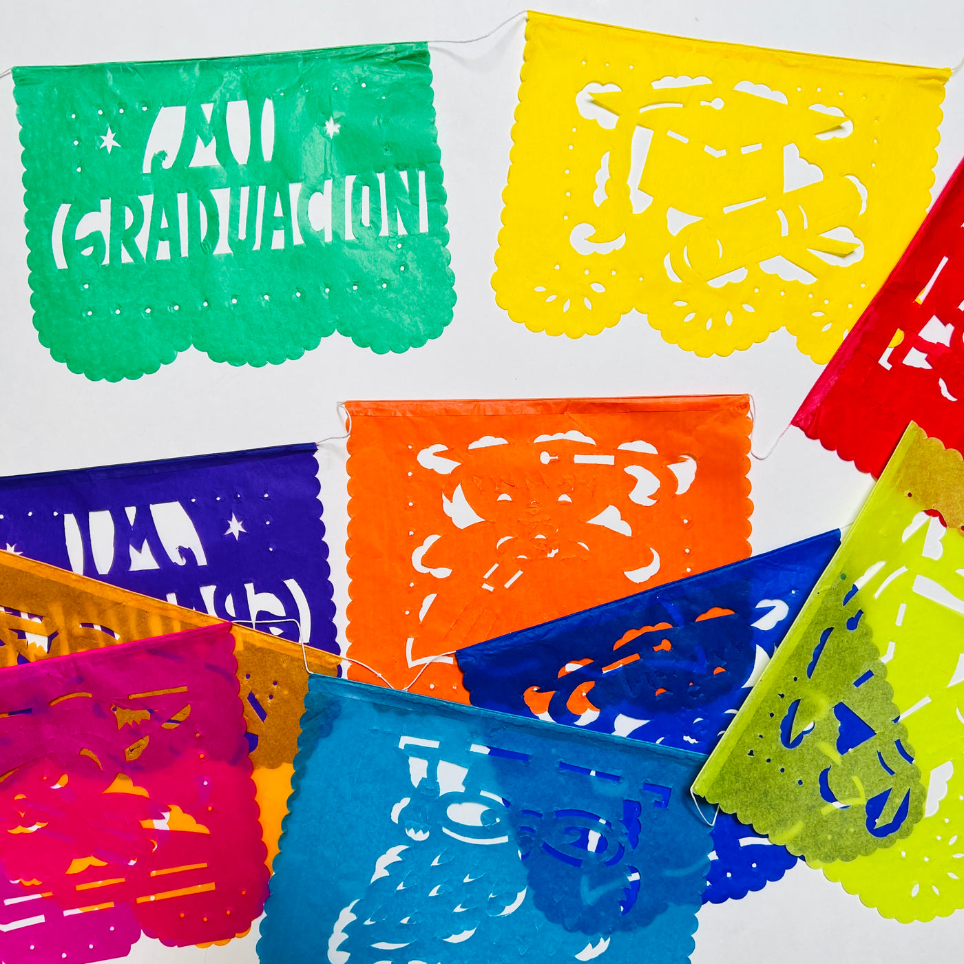 Mi Graduacion (My Graduation) papel picado banner of various colors and various grad related designs. Papel picado , or perforated paper, is a traditional Mexican decorative craft made by cutting elaborate designs into sheets of tissue paper.