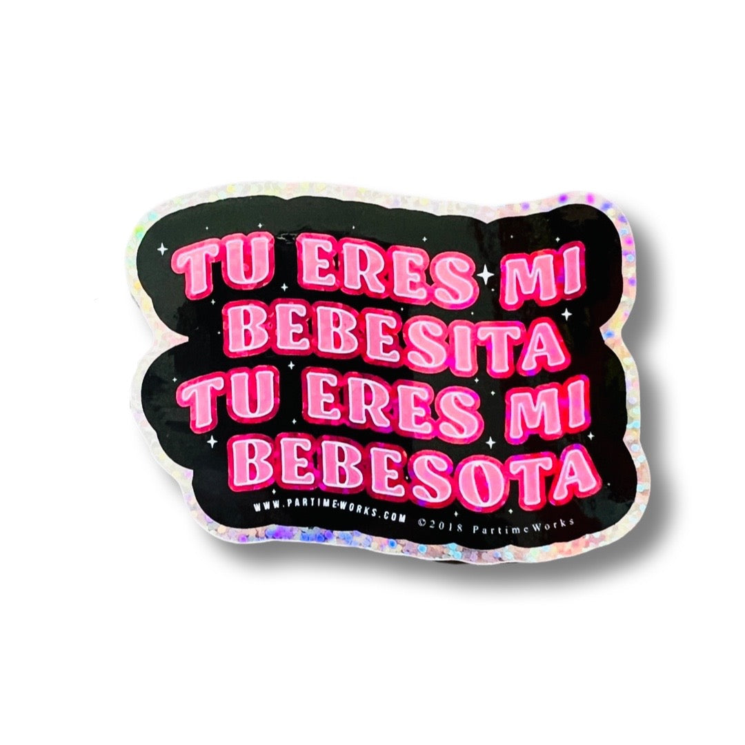 Black sticker with the phrase Tu Eres Mi Bebesita, Tu Eres Mi Bebesota in pink lettering. Features a glitter border.