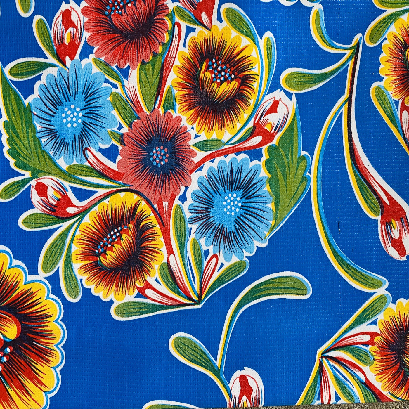 Blue bloom oilcloth table cover with colorful floral design. 