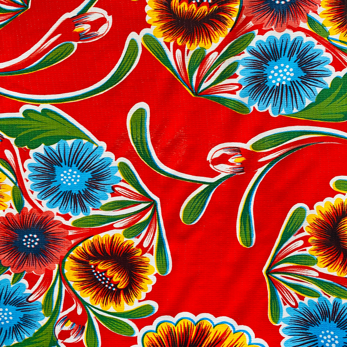 Close up of red bloom oilcloth table cover. Design features colorful floral design.