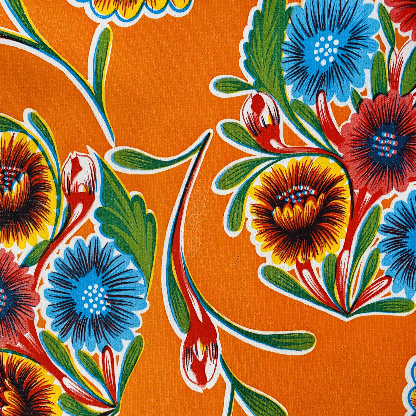 Orange bloom oilcloth table cover with colorful floral design.