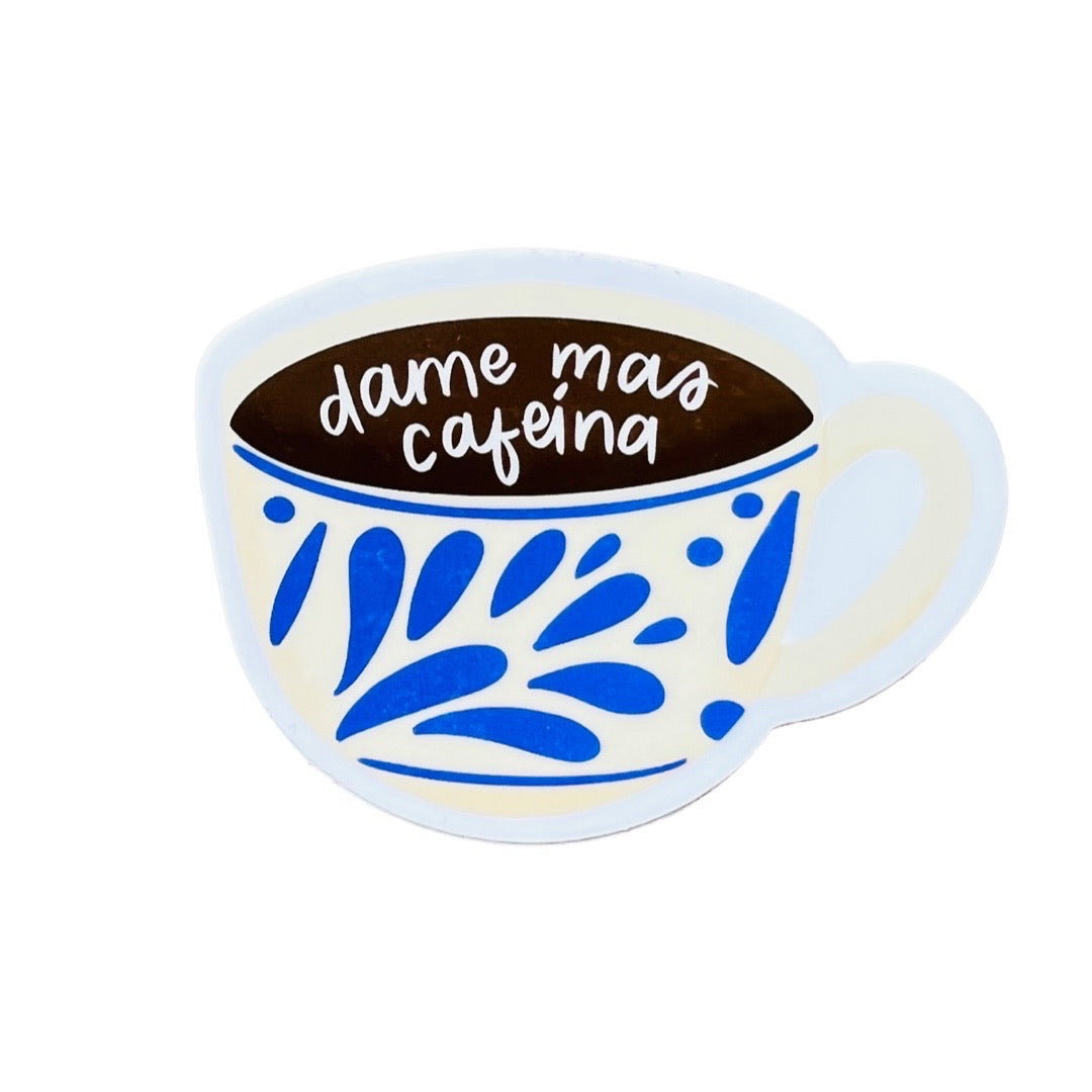 Photo of our Dame Mas Cafeina Sticker. Design features an illustration of a white & blue coffee mug with text that reads "Dame mas cafeina"