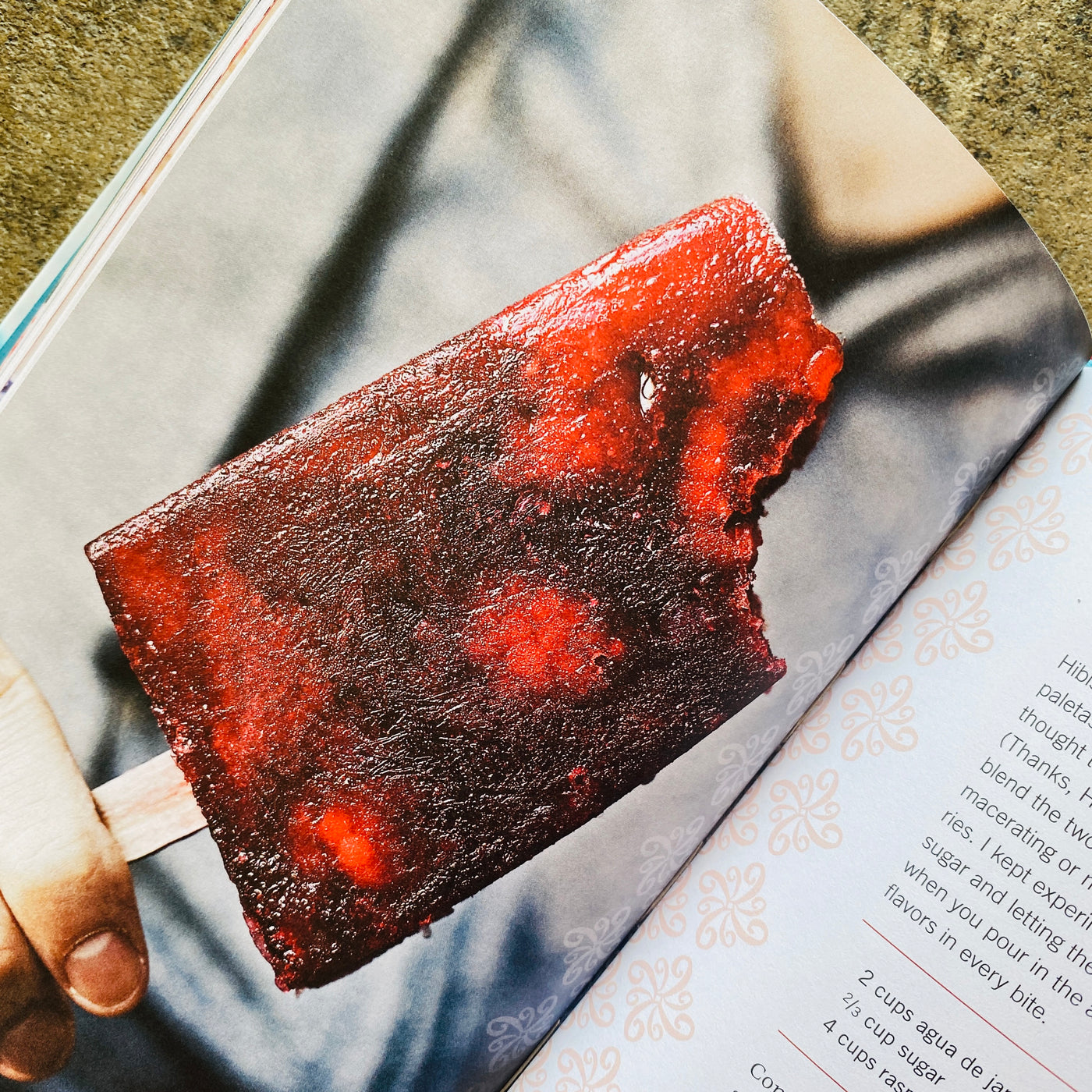 Inside look of Paletas cookbook. Image features deep red paleta with a bite mark.