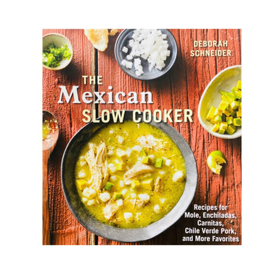 Front cover of The Mexican Slow Cooker cookbook by Deborah Schneider. Cover art is top view photo of soup in a bowl surrounded by different condiments.  Items are on a wooden table.